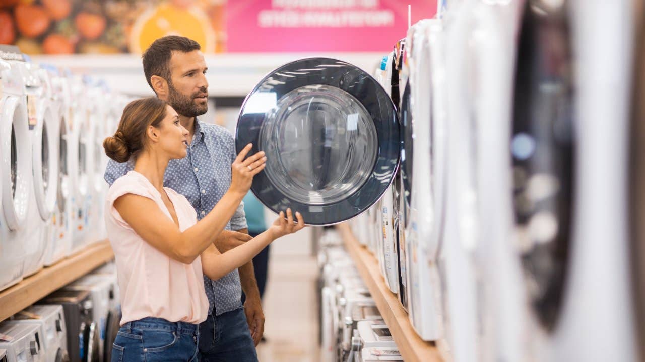 Woman Loading Washing Machine In Kitchen High-Res Stock Photo - Getty Images