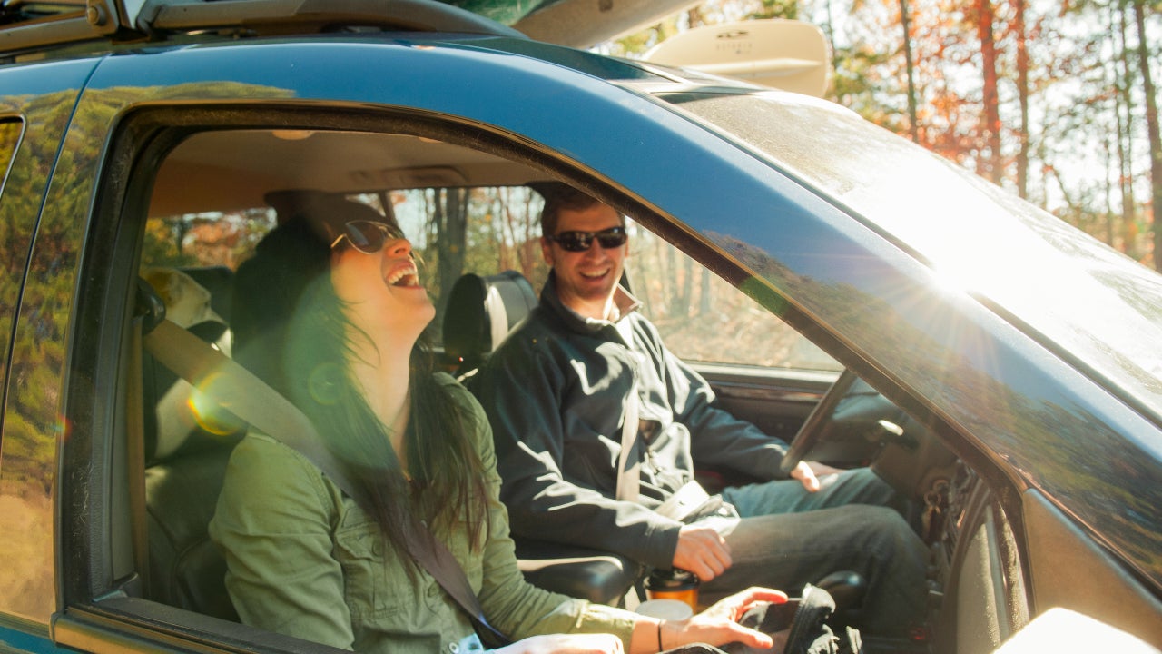 Woman and man in car, both laughing