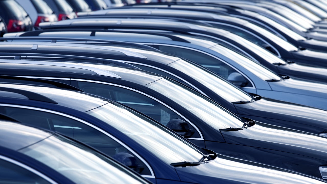 The tops of several dark colored sedans taken from profile