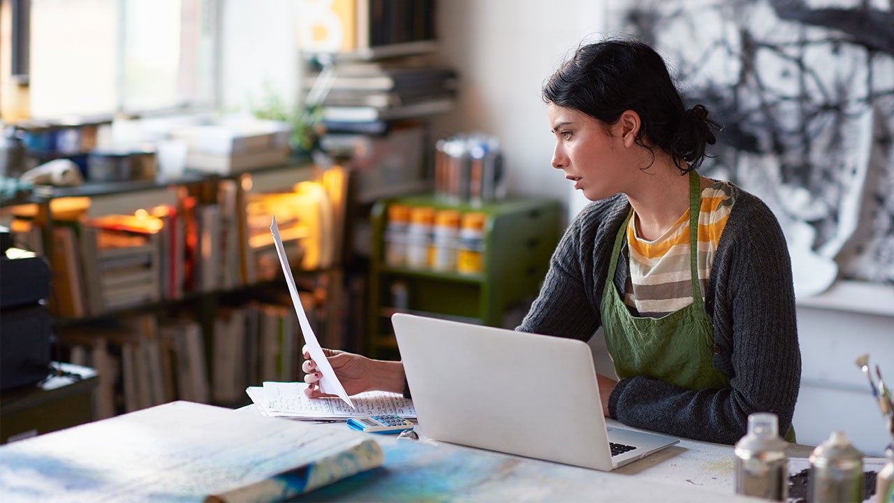 Woman reading papers and laptop