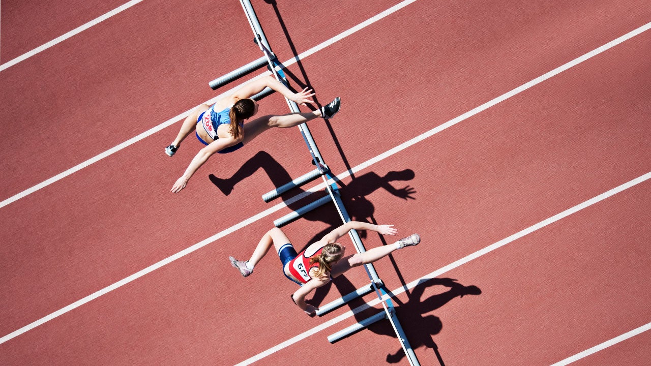 women jumping hurdles race