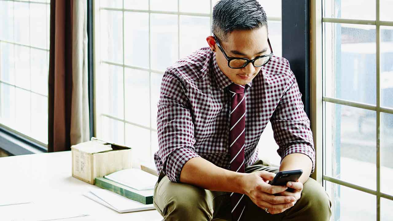 Professional young man working on smartphone in office