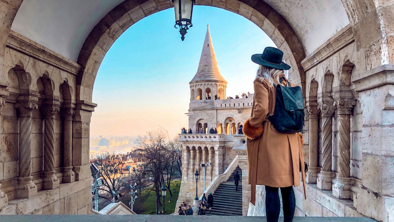 Woman looking out over steps of historic building in Budapest