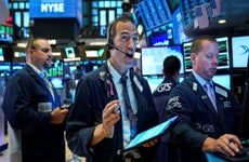 Traders on the floor of the New York Stock Exchange react to news