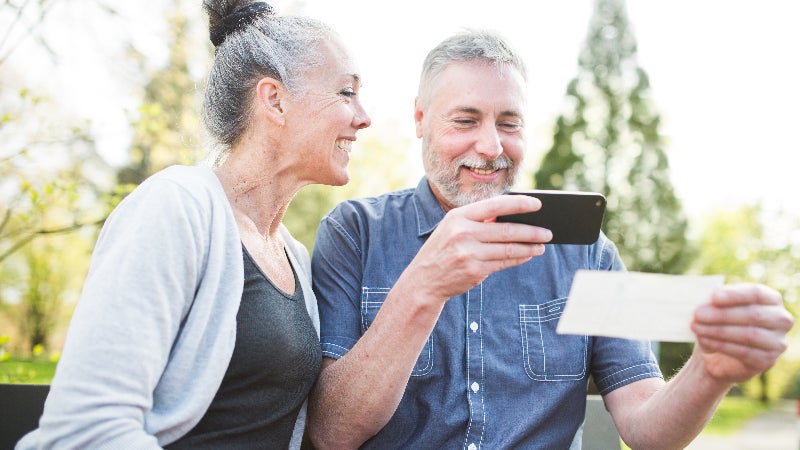 twee personen die mobiel een cheque deponeren