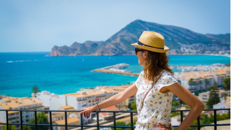  Une voyageuse contemple un paysage marin pittoresque depuis un balcon 