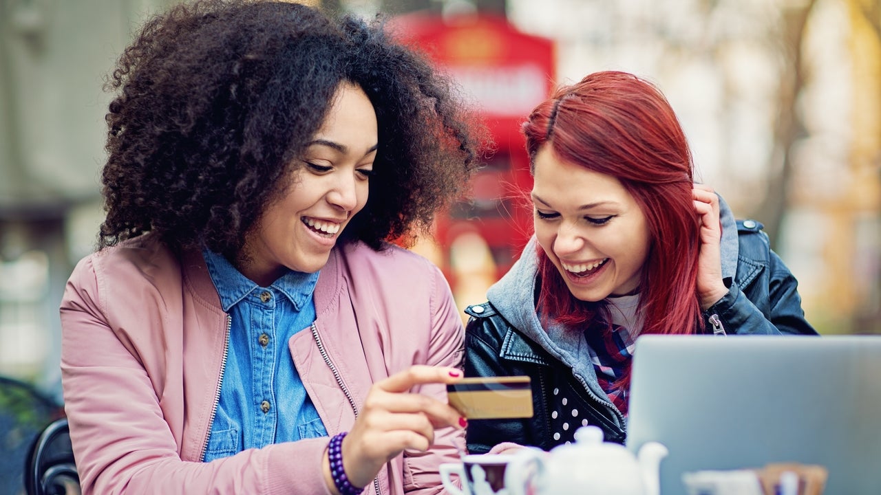 Two girlfriends are shopping online in the cafeteria