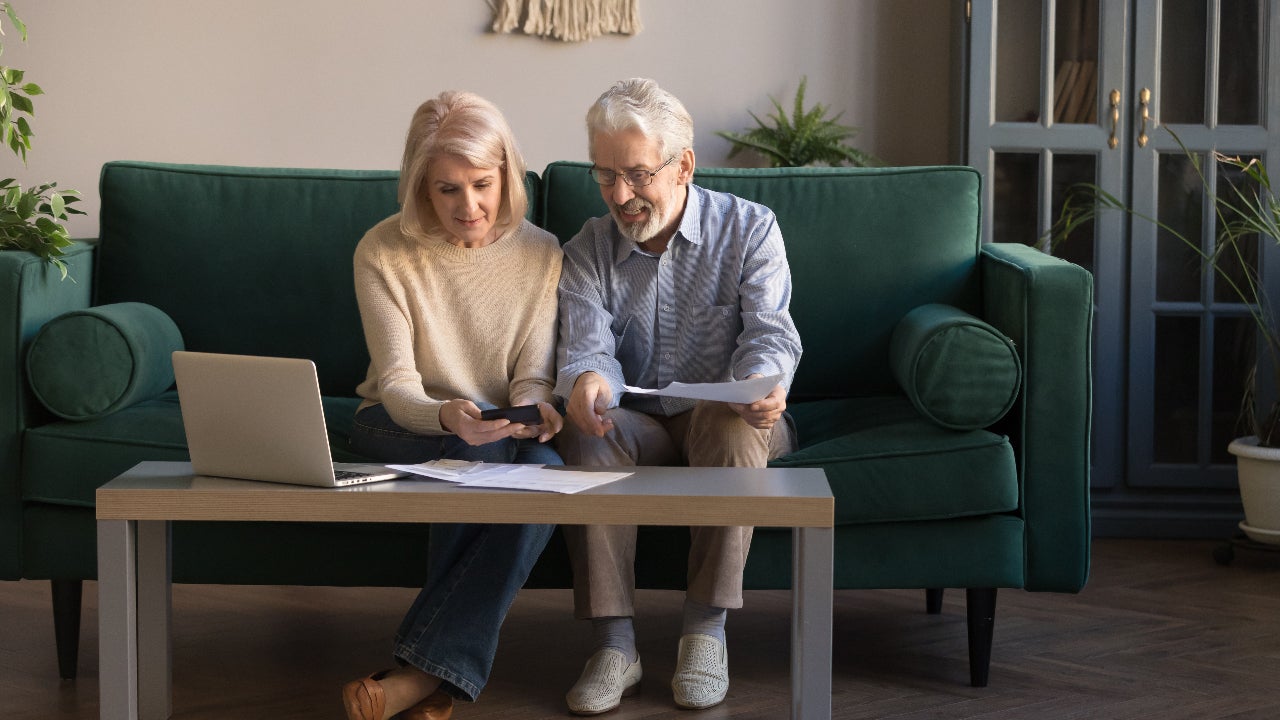 An older couple researches their finances together.