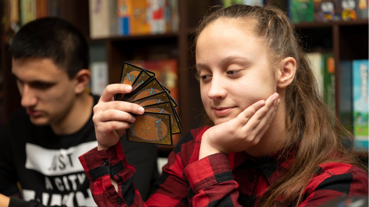 Girl plays Magic: The Gathering game