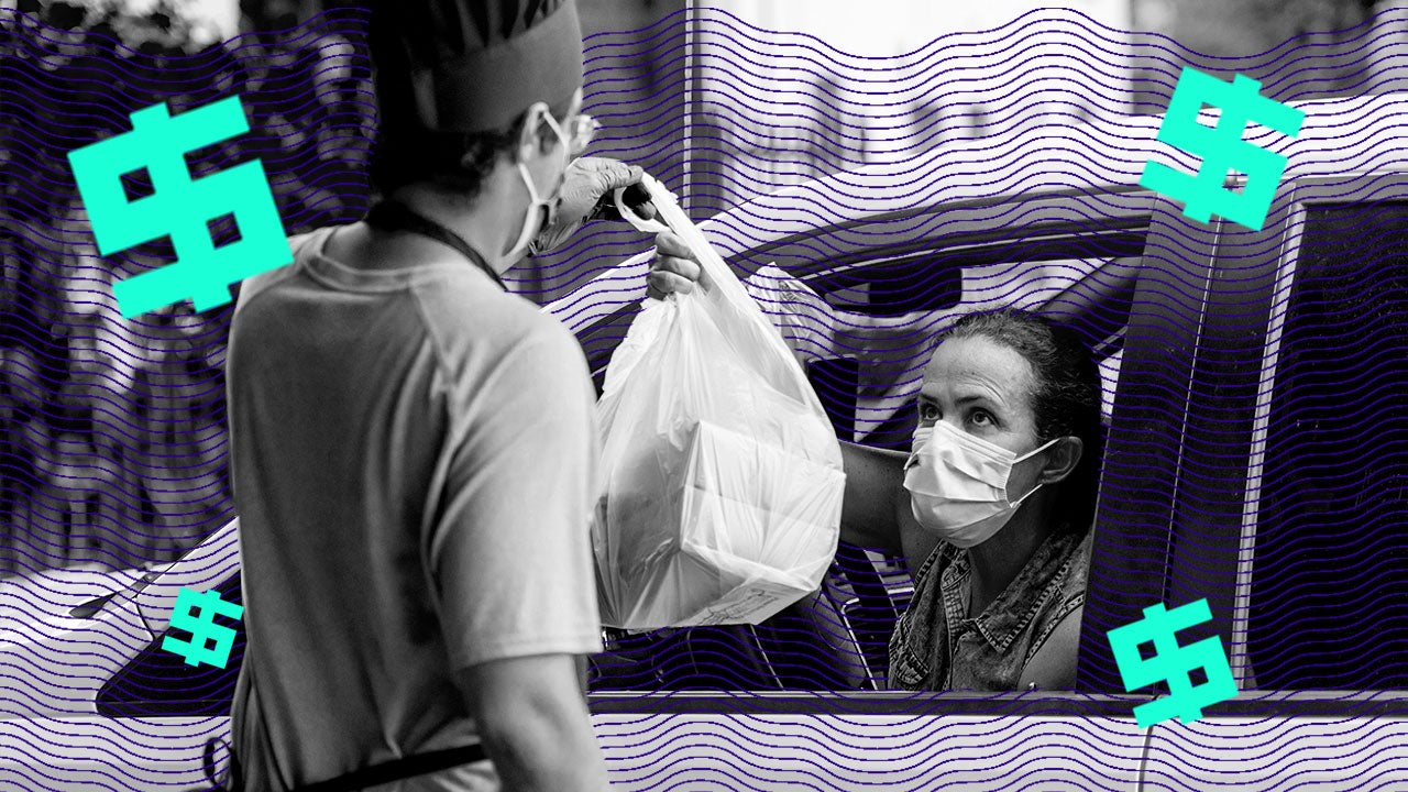 A restaurant worker hands a bag to a woman with a facemask