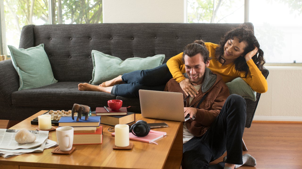 A young couple relaxes and laughs on their couch