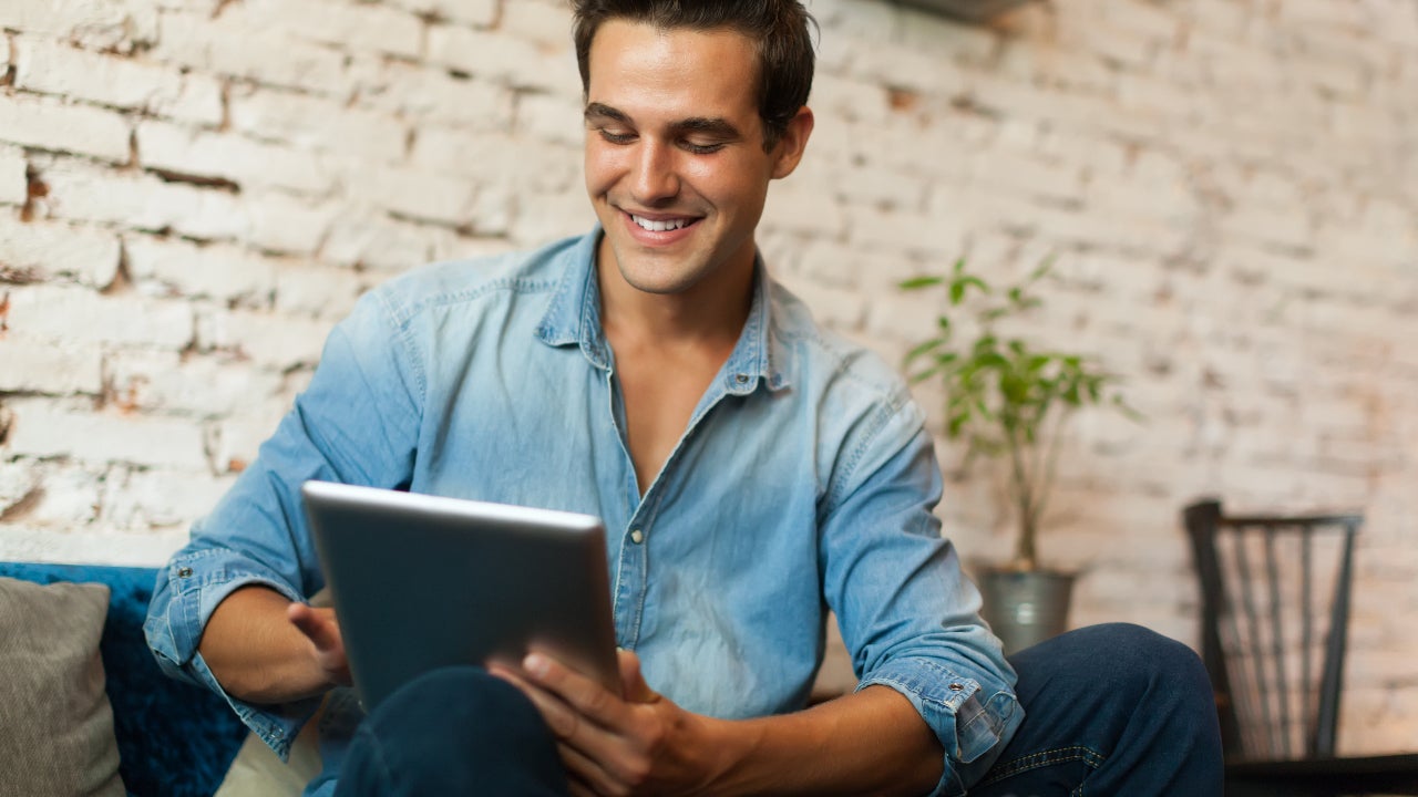 A man researches on a tablet.