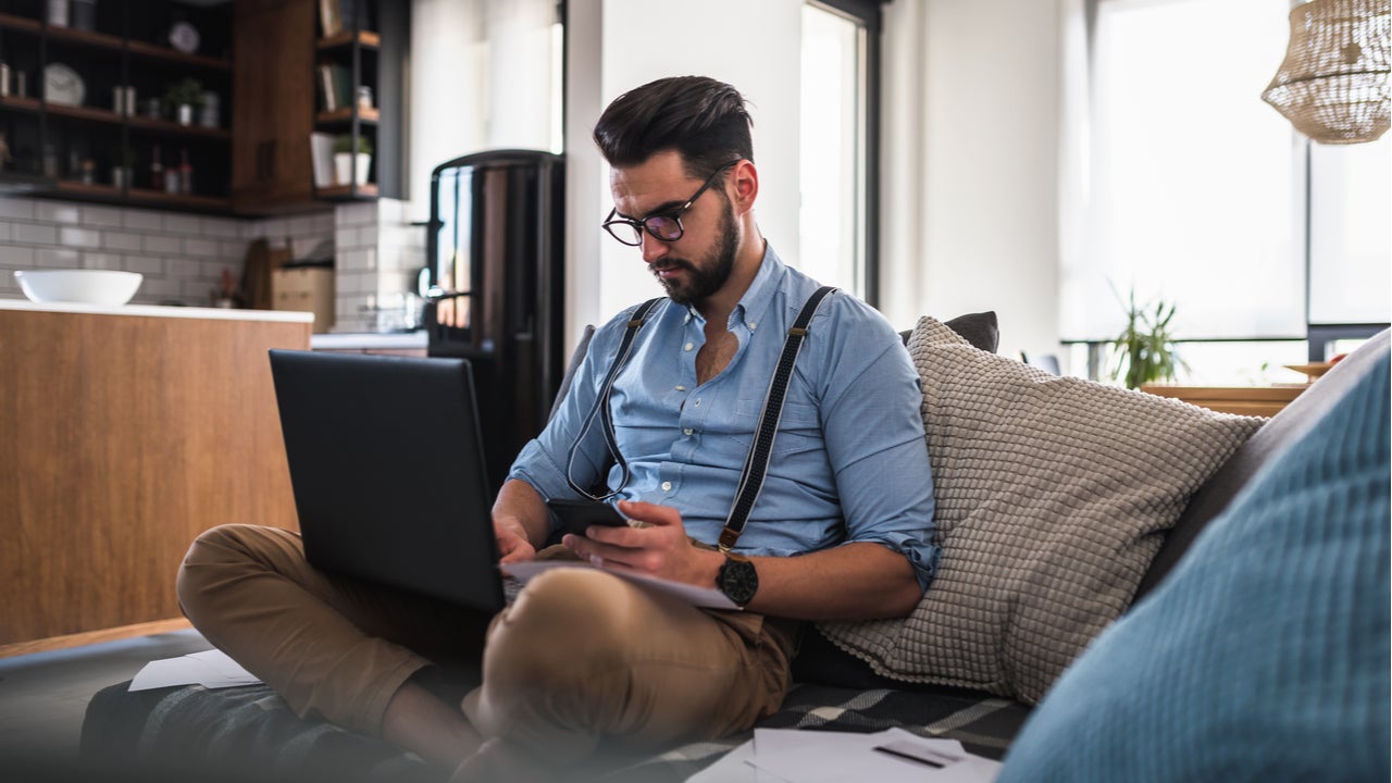 Man works on computer at home.