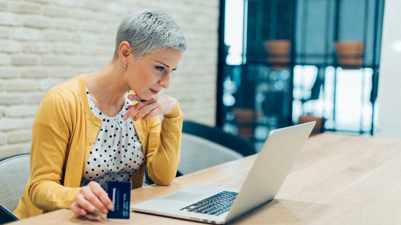 Person looking at laptop with credit card