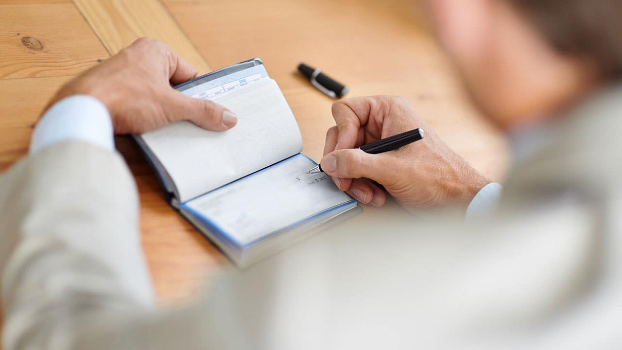 man signing a check