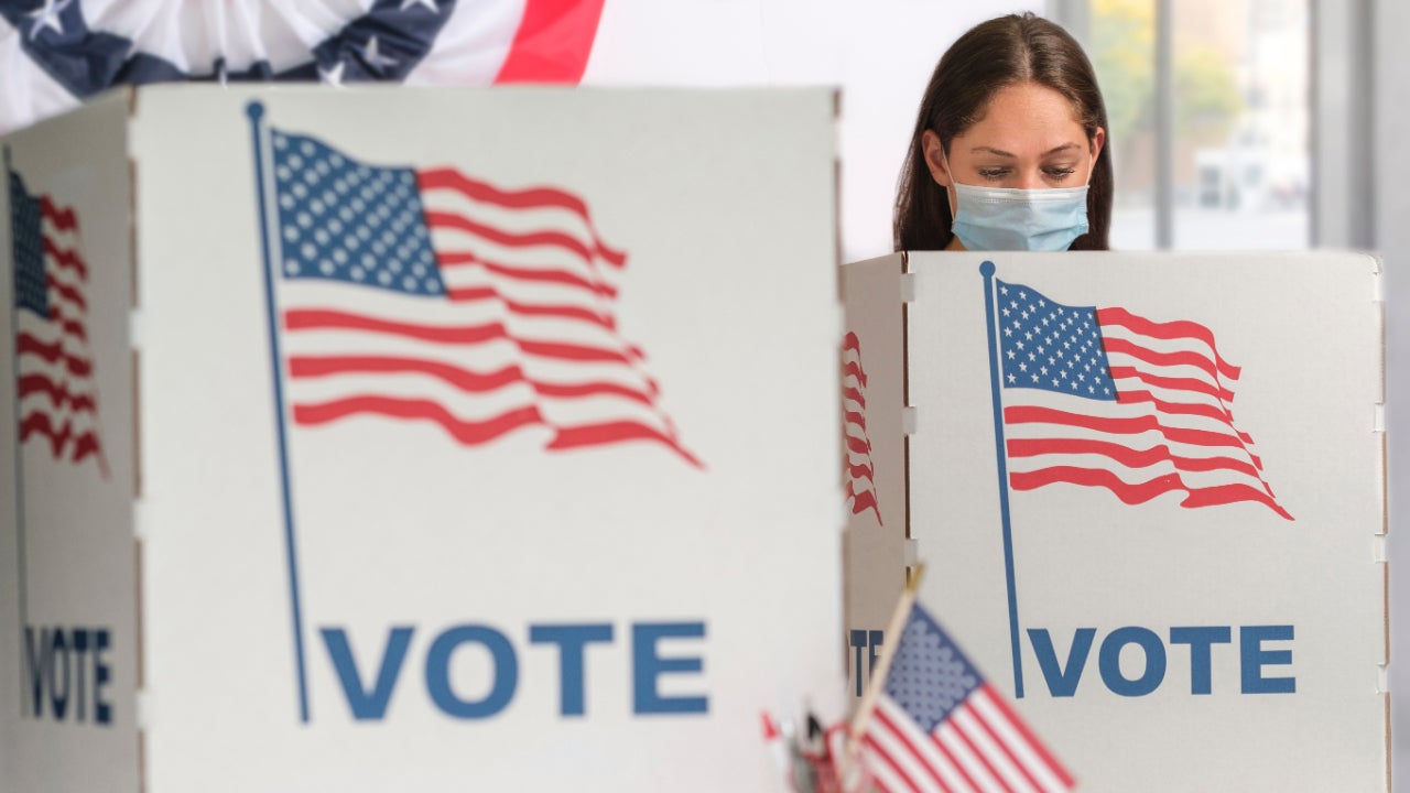 Woman voting in a face mask at the polls