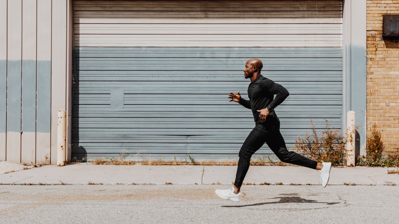 Side view of man jogging in city