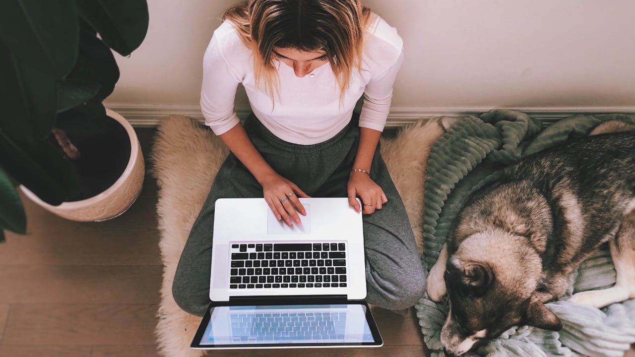 A young woman works from her laptop.