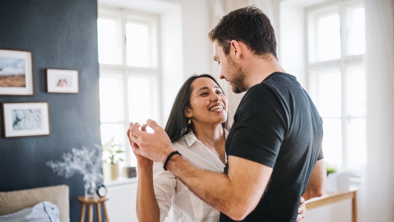 A couple dances in their living room.