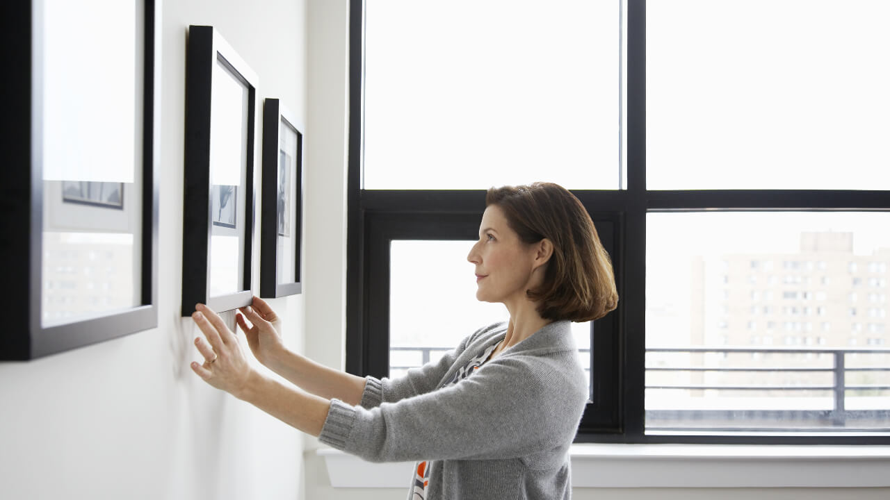 Woman hanging pictures