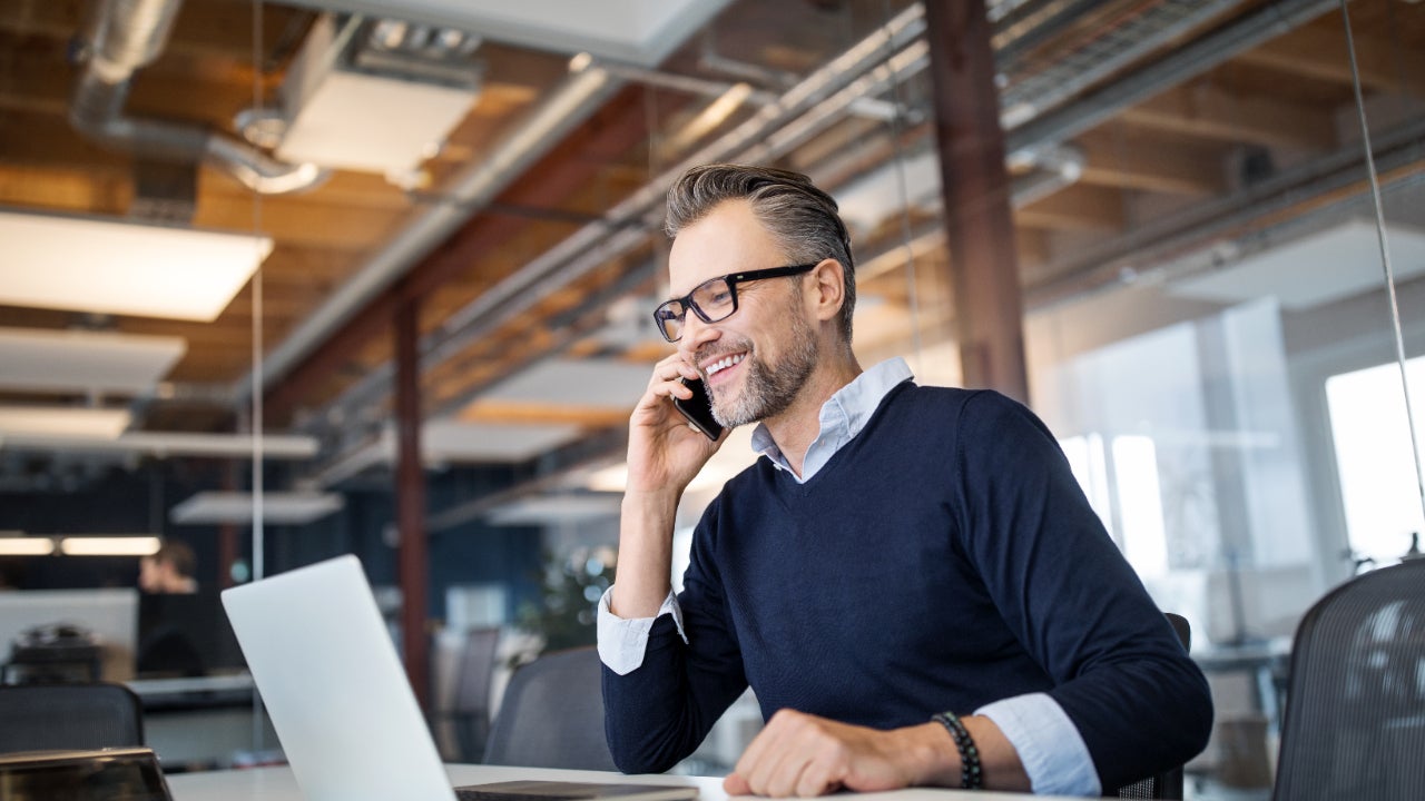 A middle aged White guy sits at an office desk