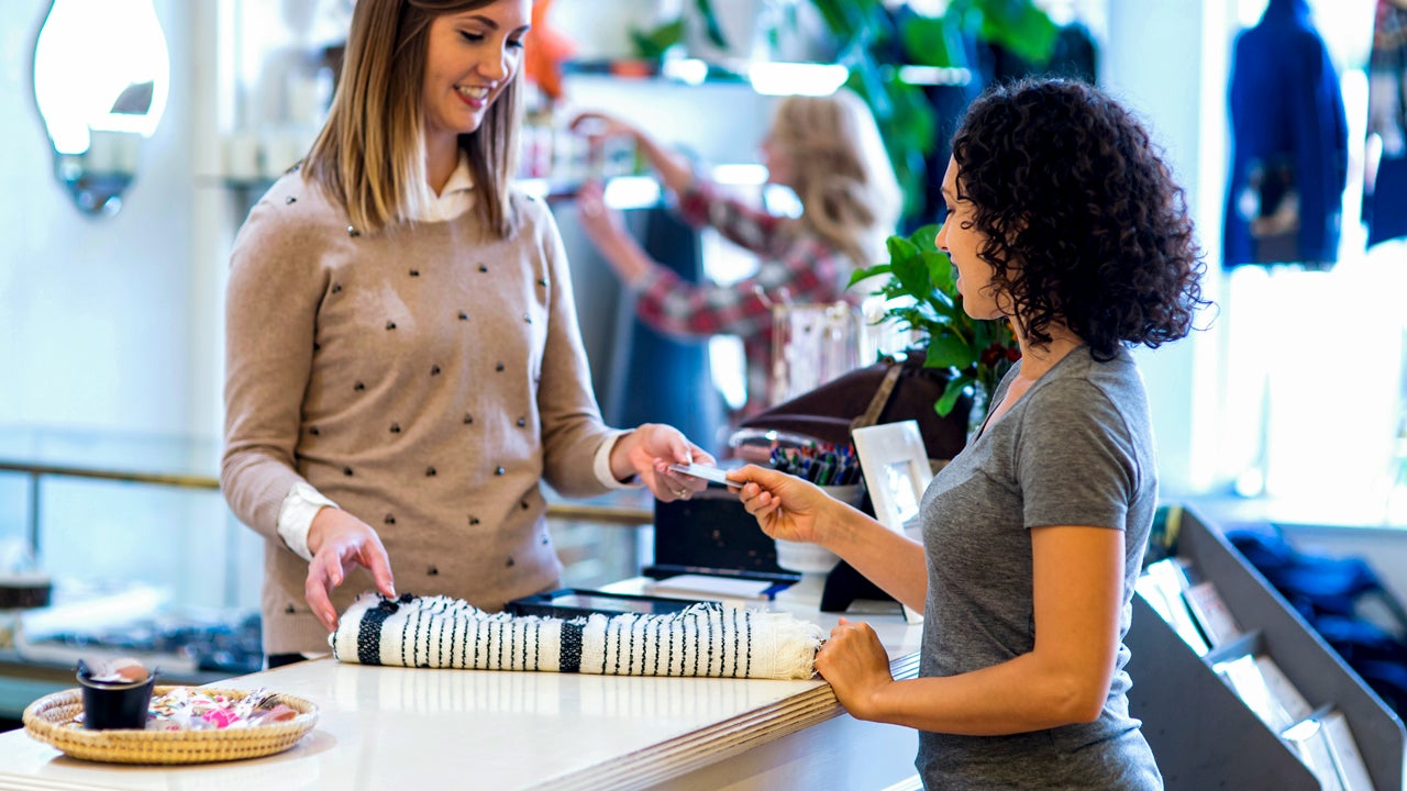 women handing over credit card at counter store