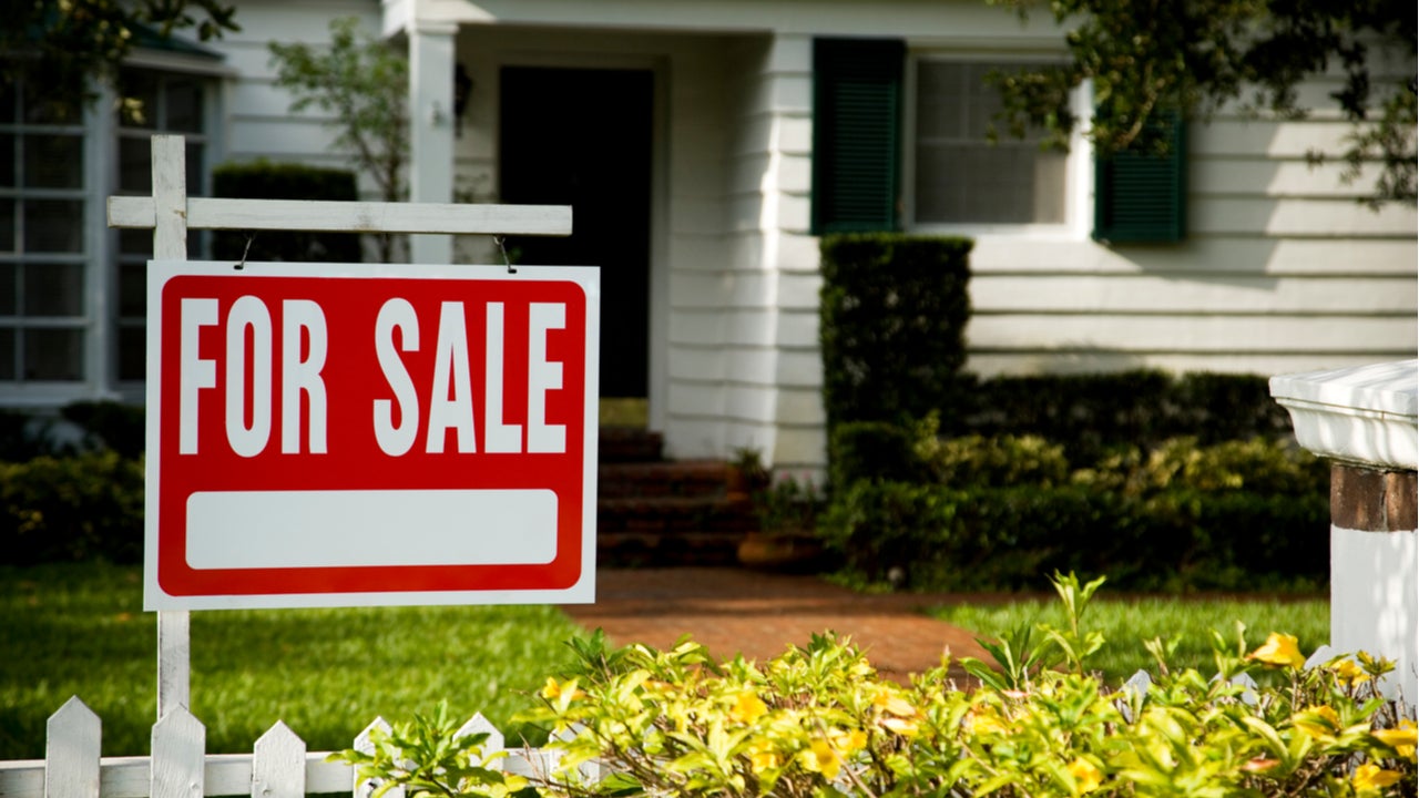 A house with a for-sale sign in the yard