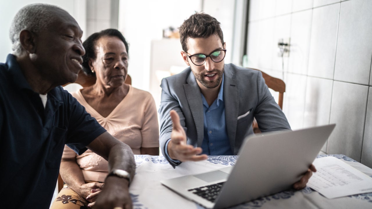 A life insurance agent goes over some possibilities with two clients (both senior African Americans)