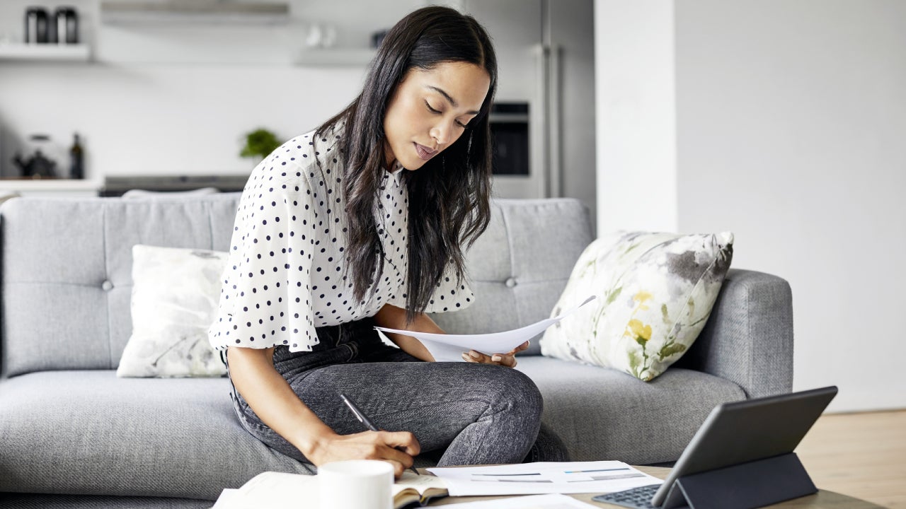 Woman analyzing documents while sitting at home