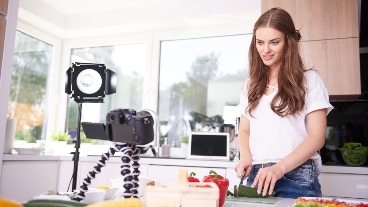 Una joven blanca filma una preparación de comida para Youtube