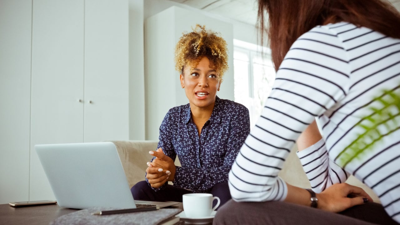 Mid adult businesswoman talking with customer