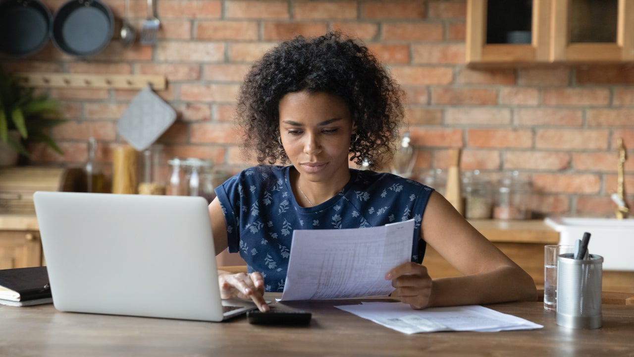 Woman looks through bills at a table