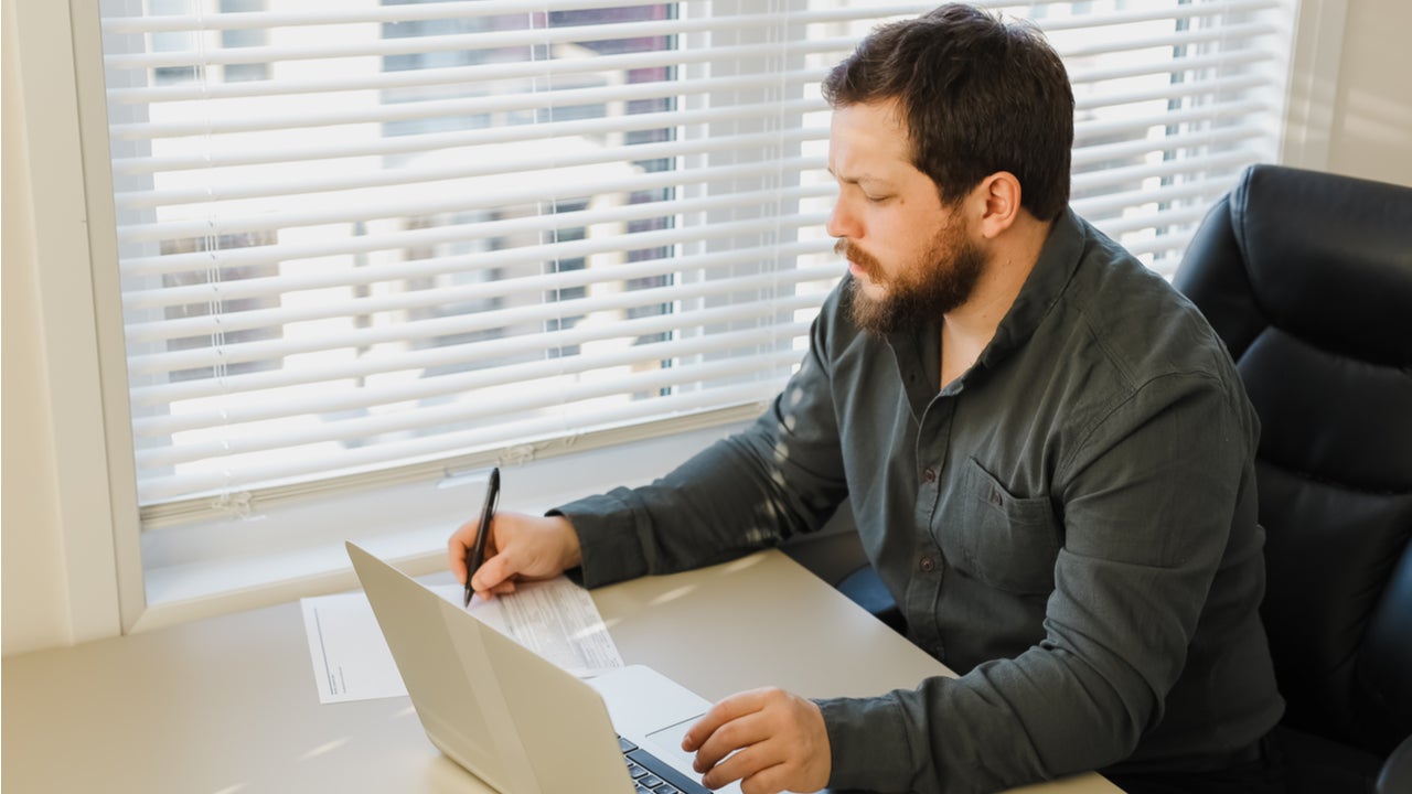 Man works on paperwork at a desk