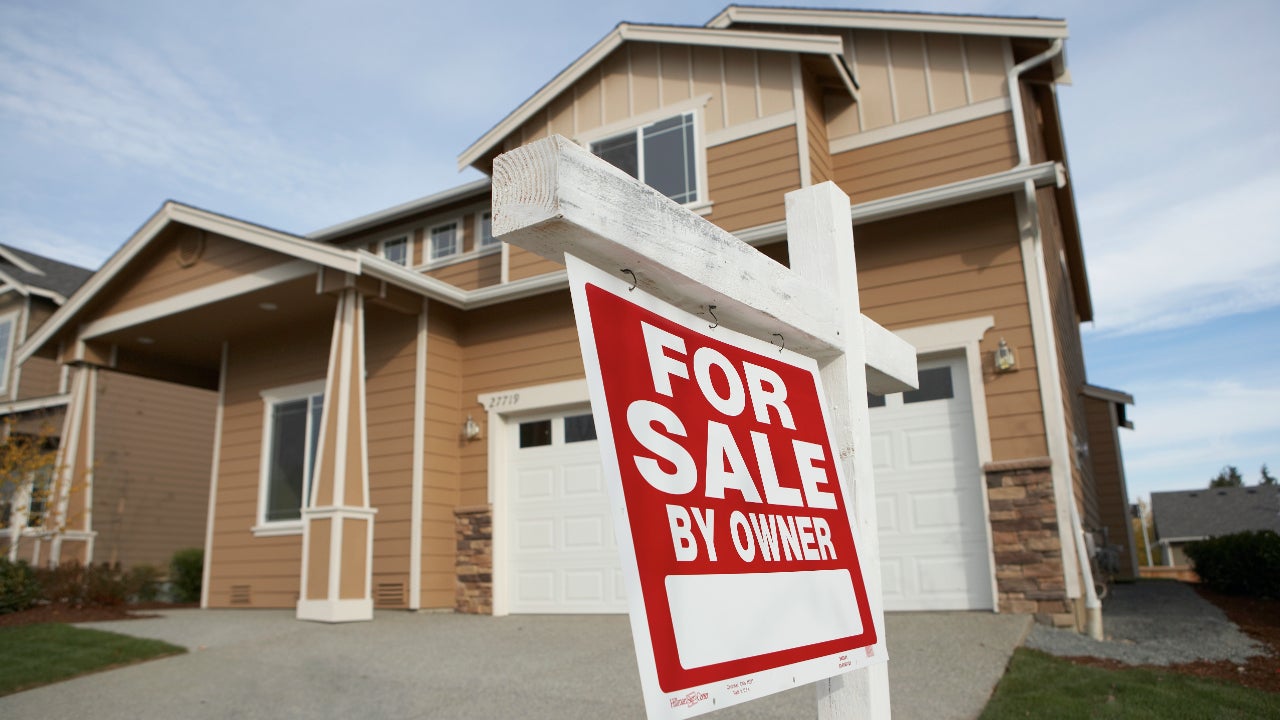 'For Sale' sign in front of house