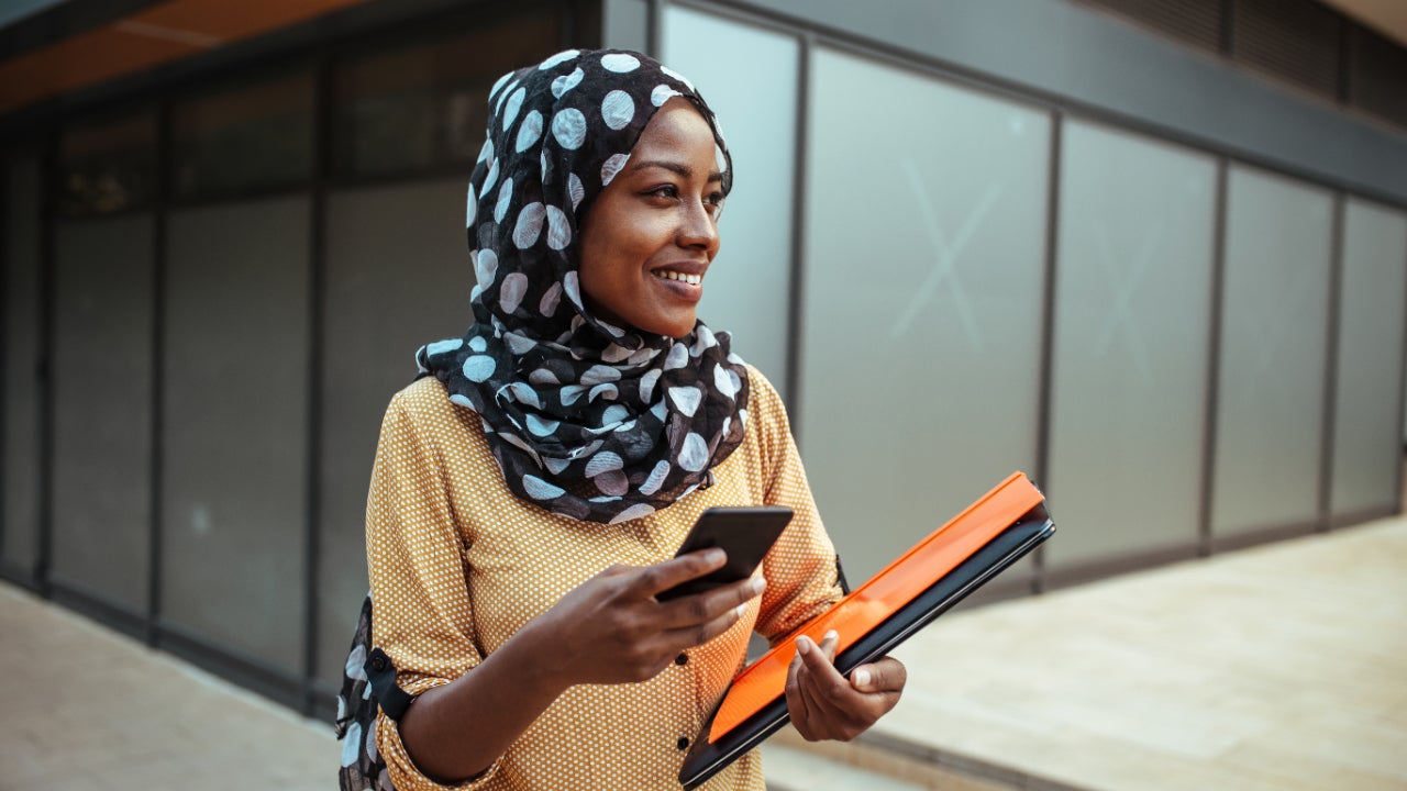 Young woman with phone and folders