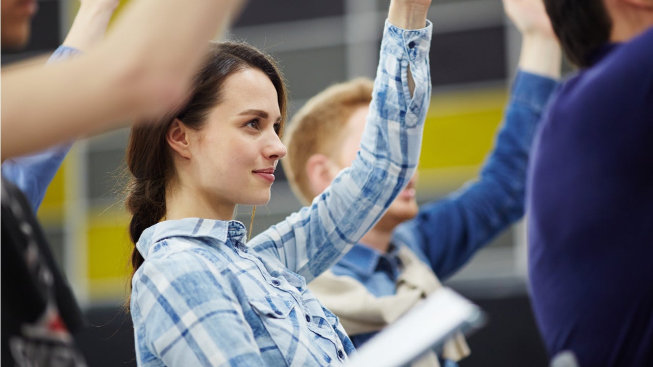 College student raises a hand in a class