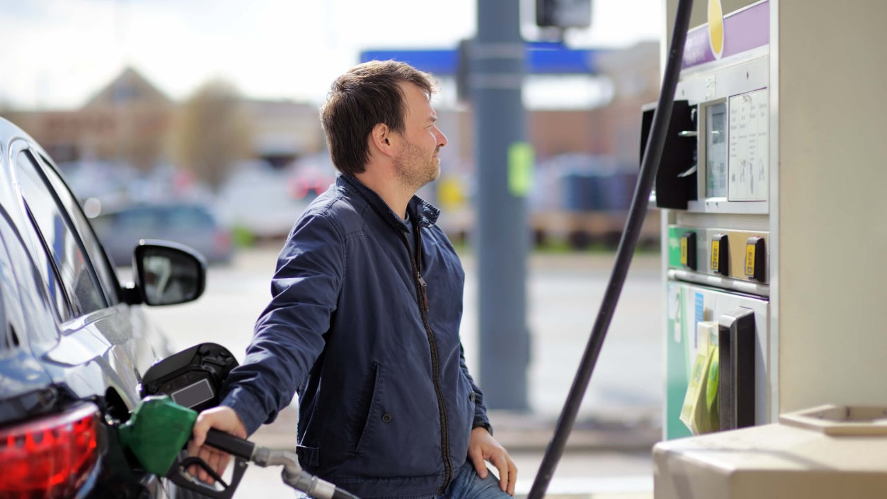 Middle-aged man pumps gas