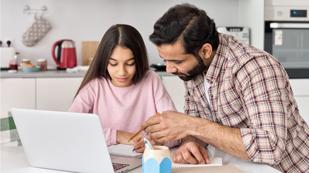 Father and daughter work on the computer together