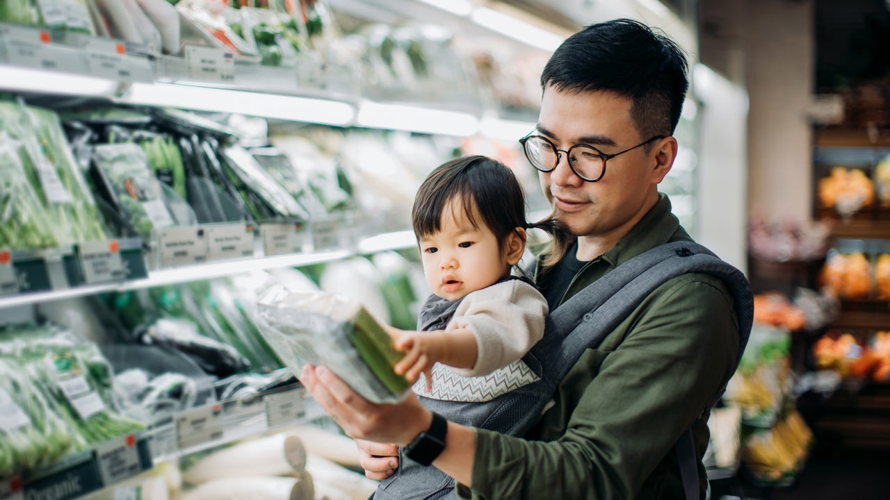 father picking out groceries with daughter