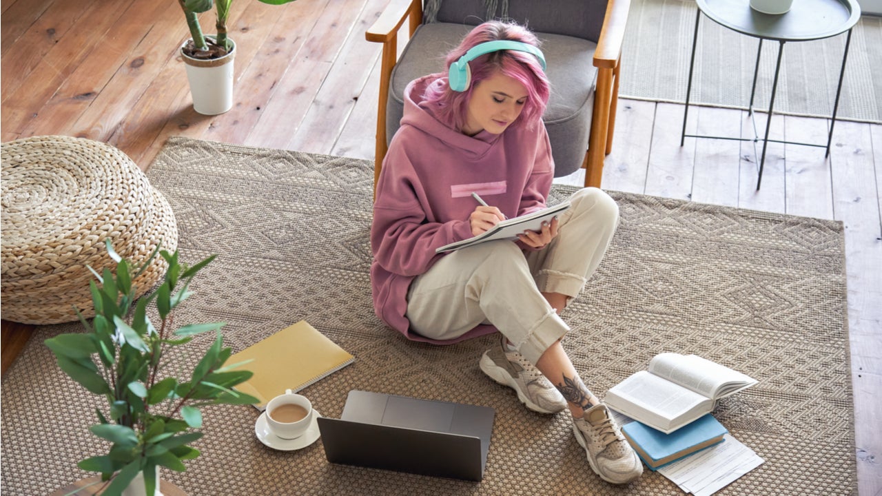 High school student sits on the floor with homework