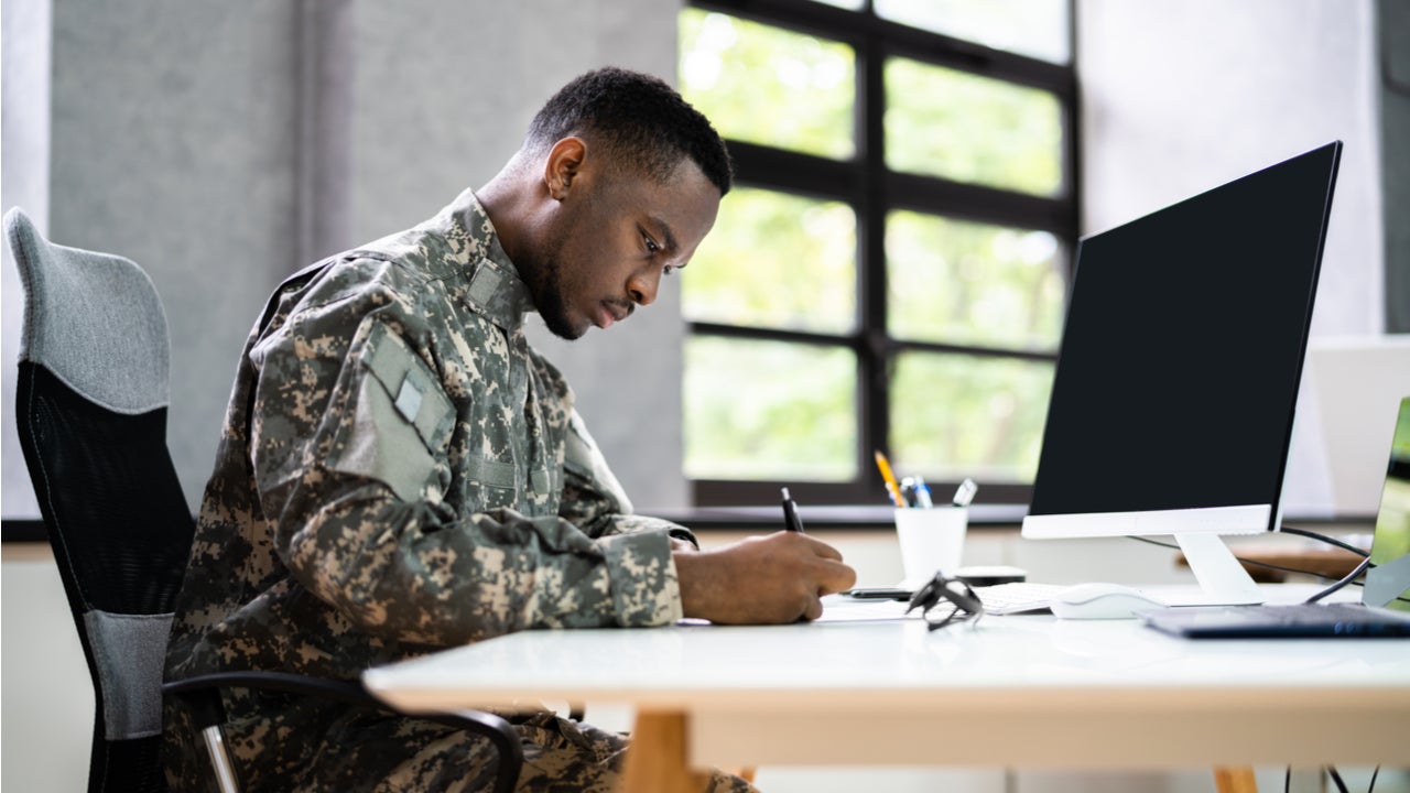 A uniformed veteran works at a desk.