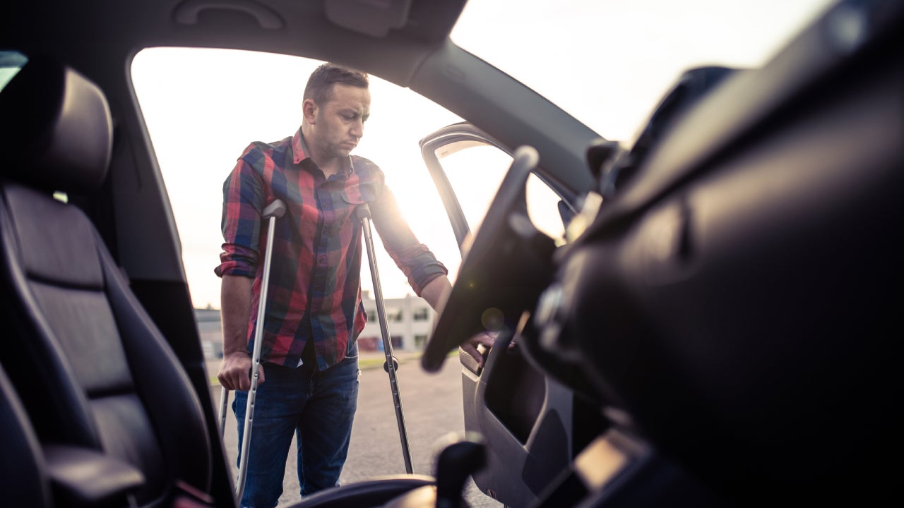 Man using crutches is about to take the car