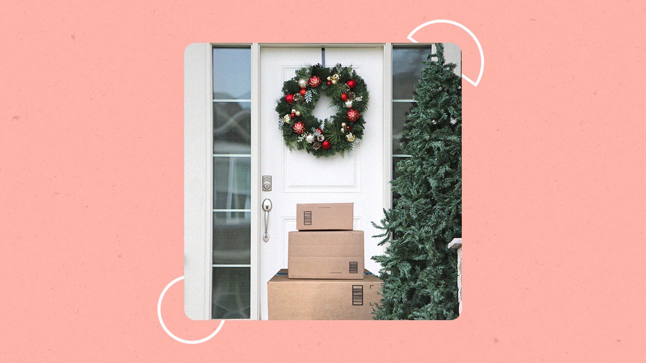 A pile of packages unattended in front of a door with a wreathe on it.