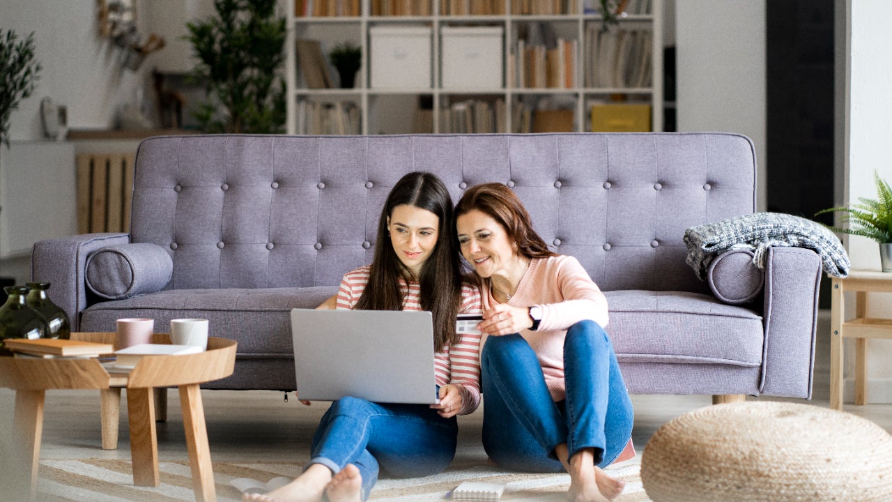 Mother and daughter looking at authorized user information on a laptop