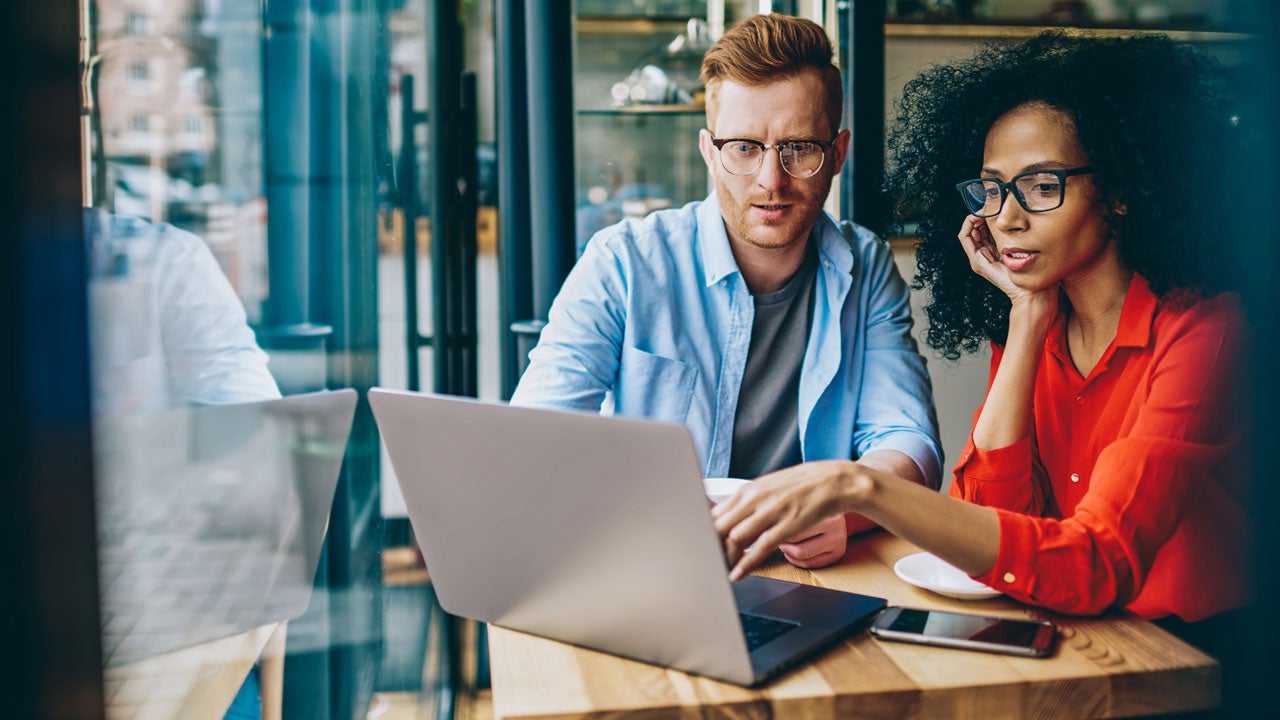 man and woman looking at computer