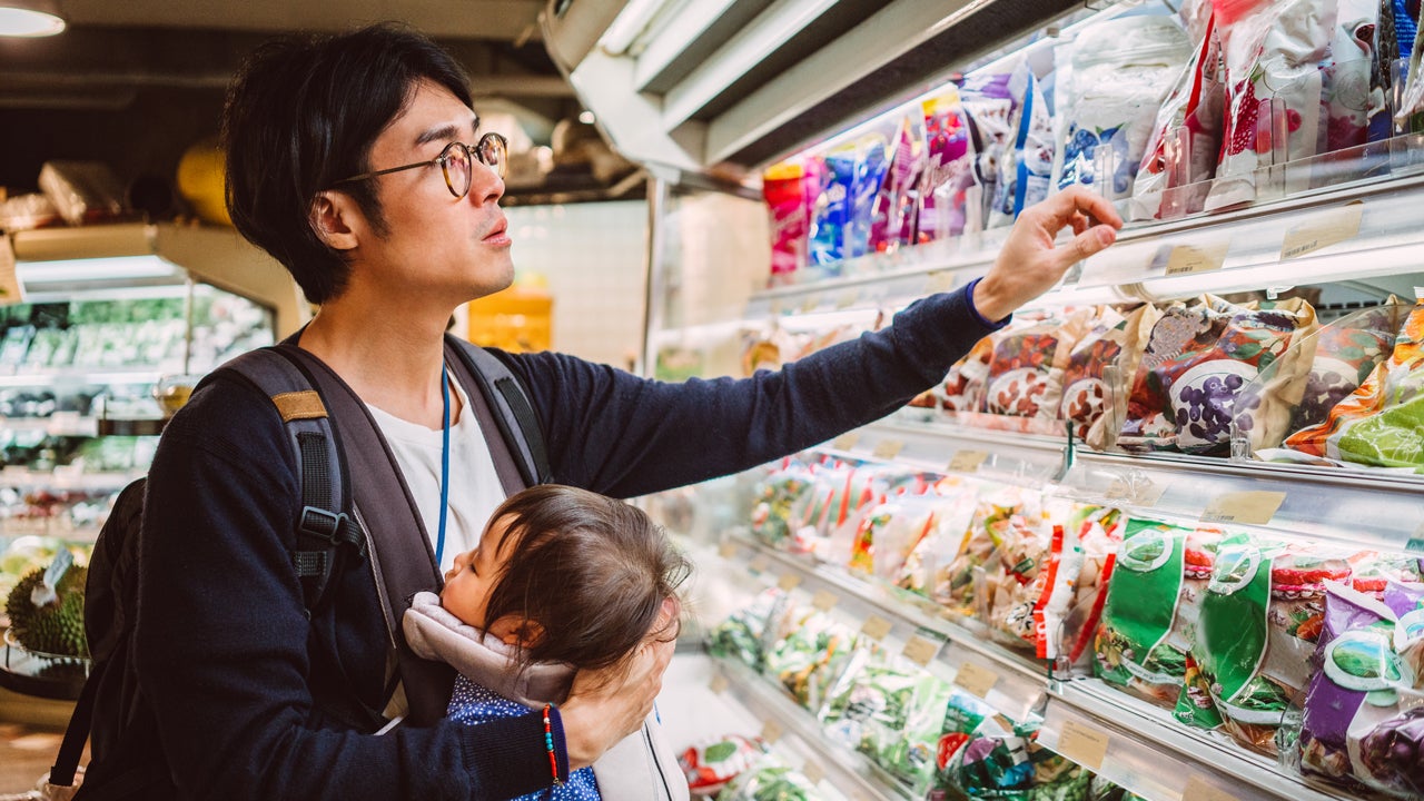 man holding child while browsing at grocery store