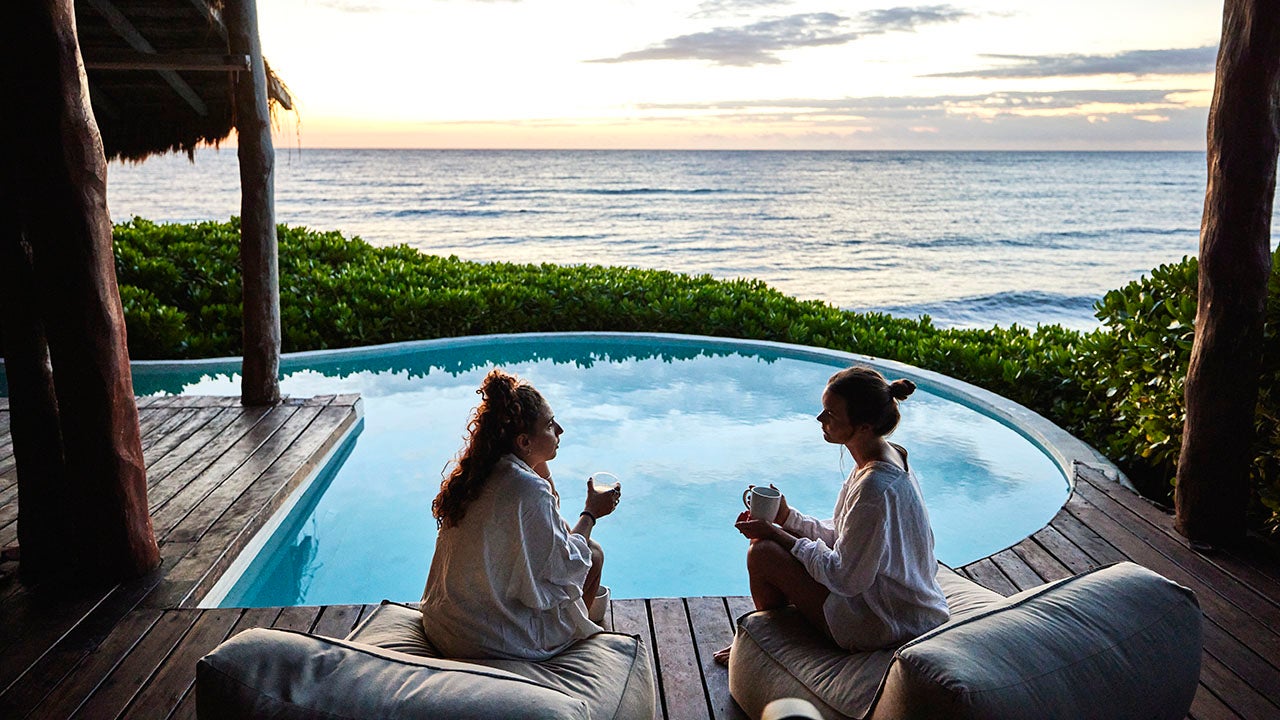 two women sitting by a hotel pool