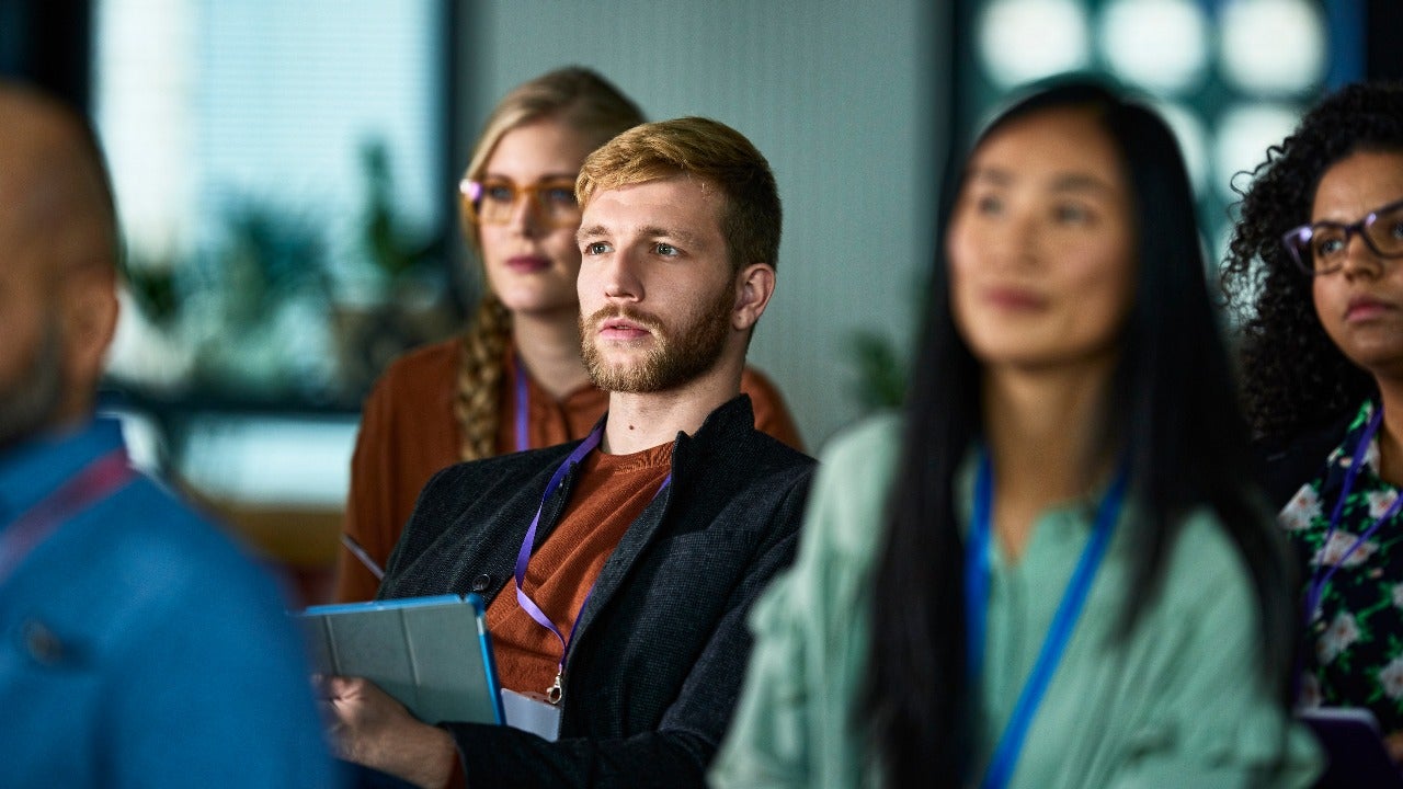 Student listens to a presentation at a conference