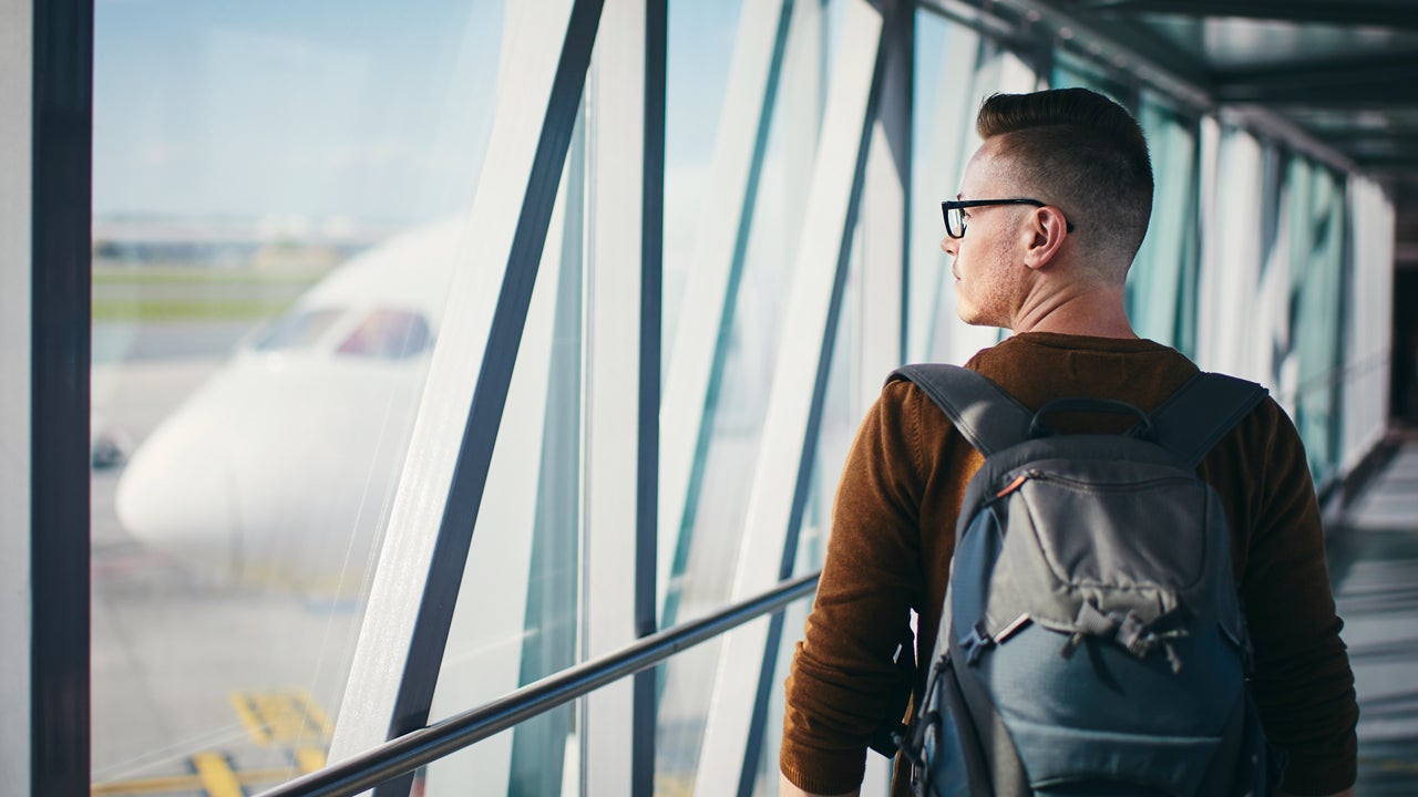 man walking in airport passenger bridge