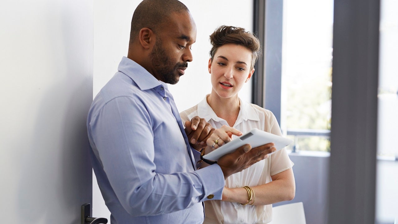 Couple standing up and looking at tablet together